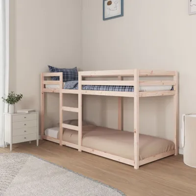 A wooden bunk bed set up in a bedroom, with bedding and a small chest of drawers.