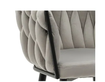 Close-up of a light grey upholstered chair with a black metal frame.