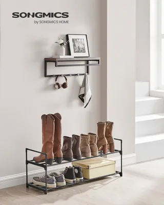 A SONGMICS shoe rack with shoes and boots displayed on it, along with a shelf above with decorative items.