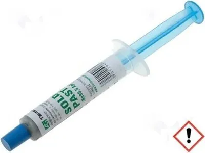 A syringe of solder paste on a white background.