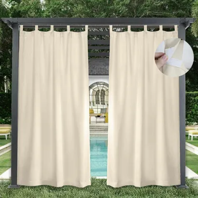 Outdoor curtains hanging on a pergola next to a swimming pool.
