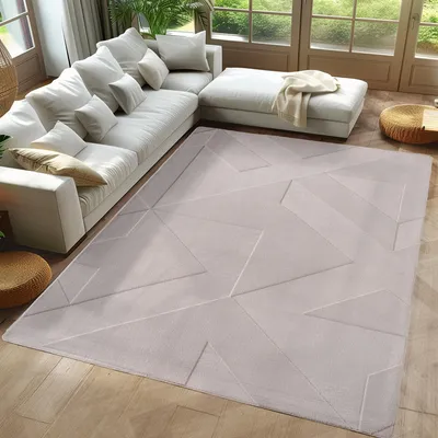 A modern living room with a large sectional sofa and a geometric patterned rug.