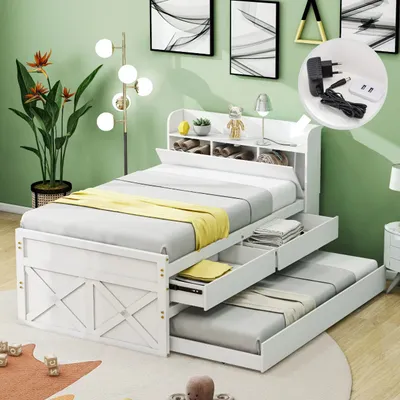 A bedroom scene featuring a white bed with a pull-out trundle and storage drawers, a floor lamp, and artwork on the wall.
