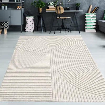 A modern living room with a rug in the foreground and a desk area in the background.