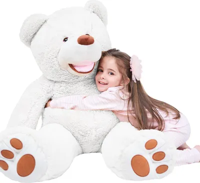 A young girl hugging a large white teddy bear.