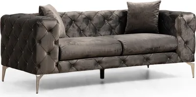 A studio shot of a tufted velvet sofa.