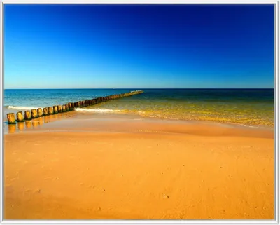 Produktbild von Wallario Wandbild Sandstrand in orange - Blaues Meer - Blauer Himmel, Größe: 40,30 x 50,30 cm, Poster mit weißem Aluminiumrahmen