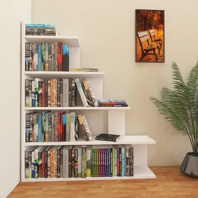 A white, tiered bookshelf filled with books, placed in a room corner next to a potted plant.