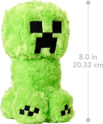 A plush toy of a Minecraft Creeper character, with a ruler indicating its size.