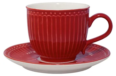 A red teacup and saucer set on a white background.