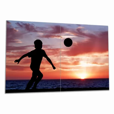Produktbild von Wallario Herdabdeckplatte aus Glas, Größe 80 x 52 cm 2-teilig, Motiv Fußball - Kleiner Junge spielt im Abendrot
