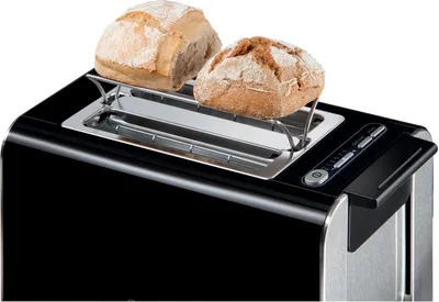 A black toaster with a chrome finish and a bread rack holding two rolls on top.