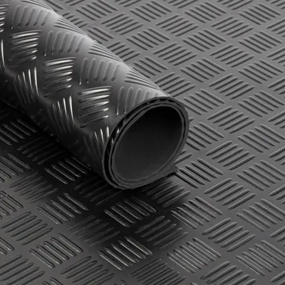 A rolled-up piece of black diamond plate flooring material.