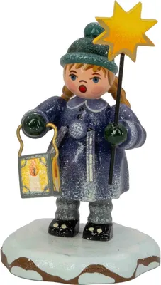 A wooden figurine of a girl in winter clothing holding a lantern and a star.