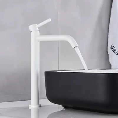 A white faucet is shown above a black sink, with water flowing from the faucet.