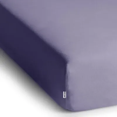 A close-up, angled view of a lavender fitted sheet on a white background.