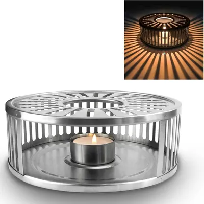 A silver tea light holder with a candle inside, casting shadows.