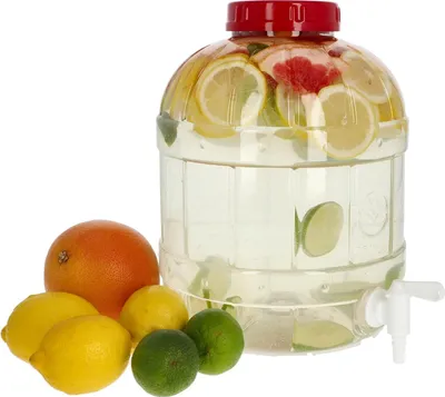 A large clear plastic beverage dispenser filled with water and citrus slices, with whole citrus fruits in front of it.