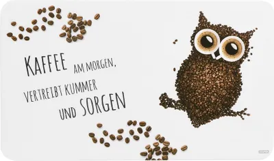 A cutting board with coffee beans arranged to form an owl and text about coffee.