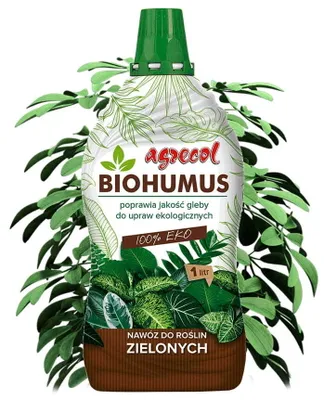 A bottle of Biohumus fertilizer for green plants, surrounded by green leaves.