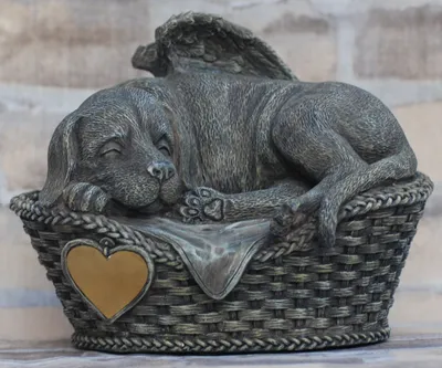 A statue of a sleeping dog with wings in a basket.