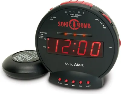 A black Sonic Alert Sonic Bomb alarm clock with a separate vibrating pad is shown against a white background.