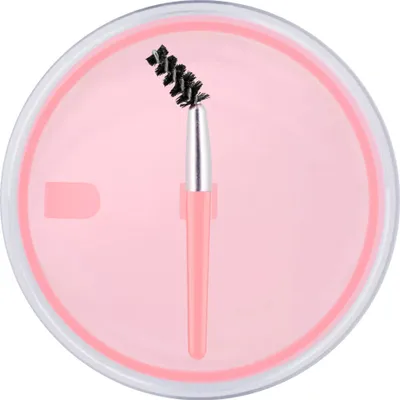 A close-up view of an eyebrow brush inside a pink container.