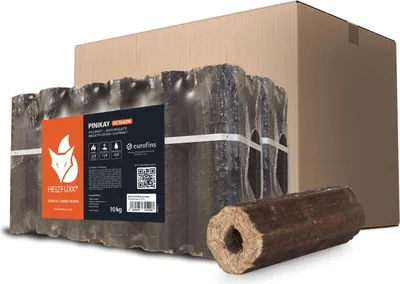 A package of wood briquettes is shown in front of a cardboard box, with one briquette in the foreground.
