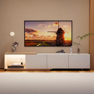 A modern living room setup featuring a TV stand with a large television displaying a scenic landscape.