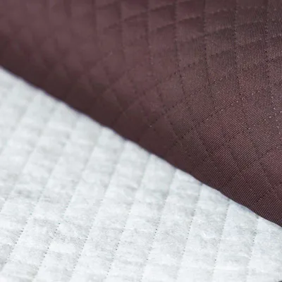 Gesteppter Oxford 600D Outdoor-Stoff in Aubergine – Detailansicht der rautenförmigen Steppung auf der Vorderseite und des weißen Futterstoffs auf der Rückseite.
