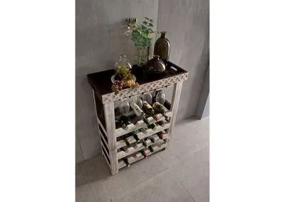 A wine rack with bottles and glasses on a light gray floor next to a textured wall.