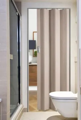 A bathroom with a toilet and a shower stall, with a folding door in the center.