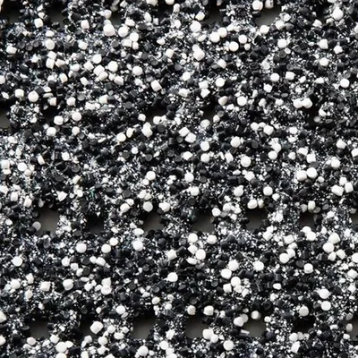 A close-up, textured view of small black and white particles, possibly representing a material or surface.