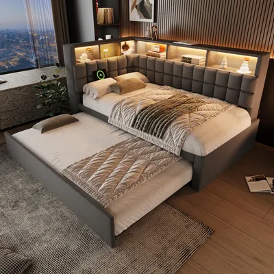 A modern bedroom with a grey upholstered bed featuring a pull-out trundle bed, integrated shelving with LED lighting, and a large window overlooking a city skyline.