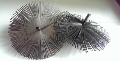 Two chimney brushes are shown on a white surface.