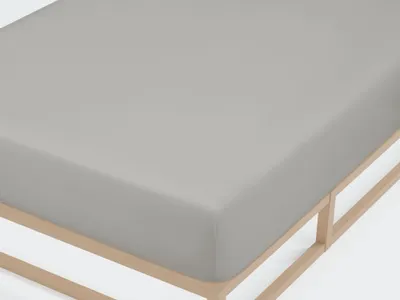 A close-up view of a gray fitted sheet on a wooden bed frame.