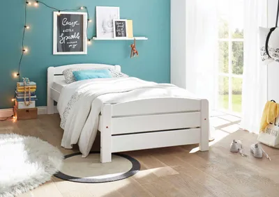 Kinderbett Einzelbett IVI Weiß aus massiver Kiefer in Gesamtansicht mit weißer Bettwäsche und türkisem Kissen.