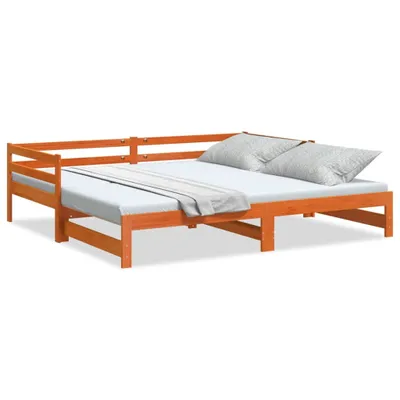 A wooden daybed with two pillows and a throw blanket.