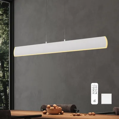 A modern white pendant light hangs over a wooden dining table with a bowl of nuts.