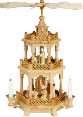 Zu sehen ist eine traditionelle Weihnachtspyramide aus Holz mit zwei Etagen auf denen Figuren stehen und an den Ecken brennen Kerzen die die Flügel oben antreiben