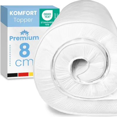 A rolled-up white mattress topper is shown next to its packaging.