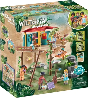 The image shows the packaging of a PLAYMOBIL Wiltopia Familienbaumhaus toy set, featuring the treehouse structure, figures, and accessories in a jungle-like environment.