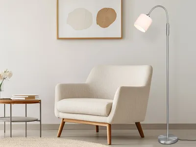 A floor lamp is positioned next to an armchair in a living room setting.