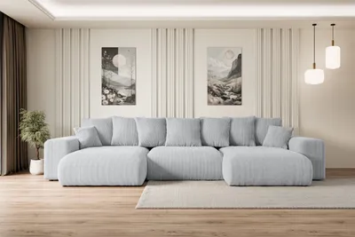 A modern living room with a large U-shaped sofa, artwork on the wall, and pendant lights.
