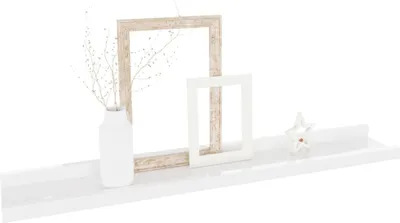 A white shelf with decorative items including two picture frames, a vase with branches, and a star-shaped ornament.