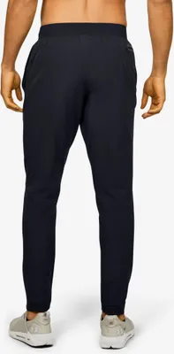 A person wearing black pants and light-colored shoes, viewed from the back.