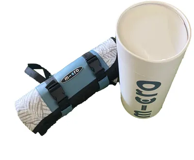 A rolled-up blanket with straps and a carrying tube, both branded with 'm-cro'.