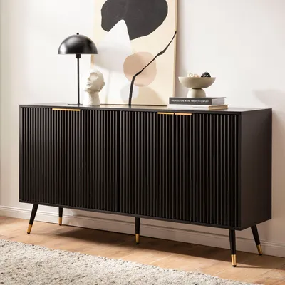A black sideboard with gold accents is displayed in a room with a rug and artwork.