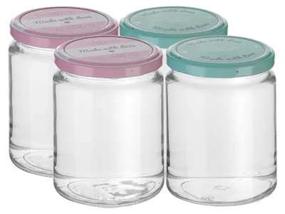 Four glass jars with decorative lids are arranged in a group.