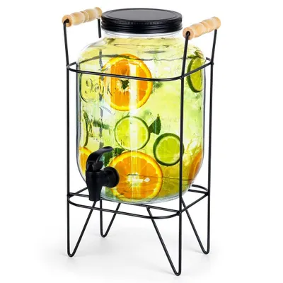 A glass beverage dispenser with a spigot and a metal stand, filled with water and fruit slices.